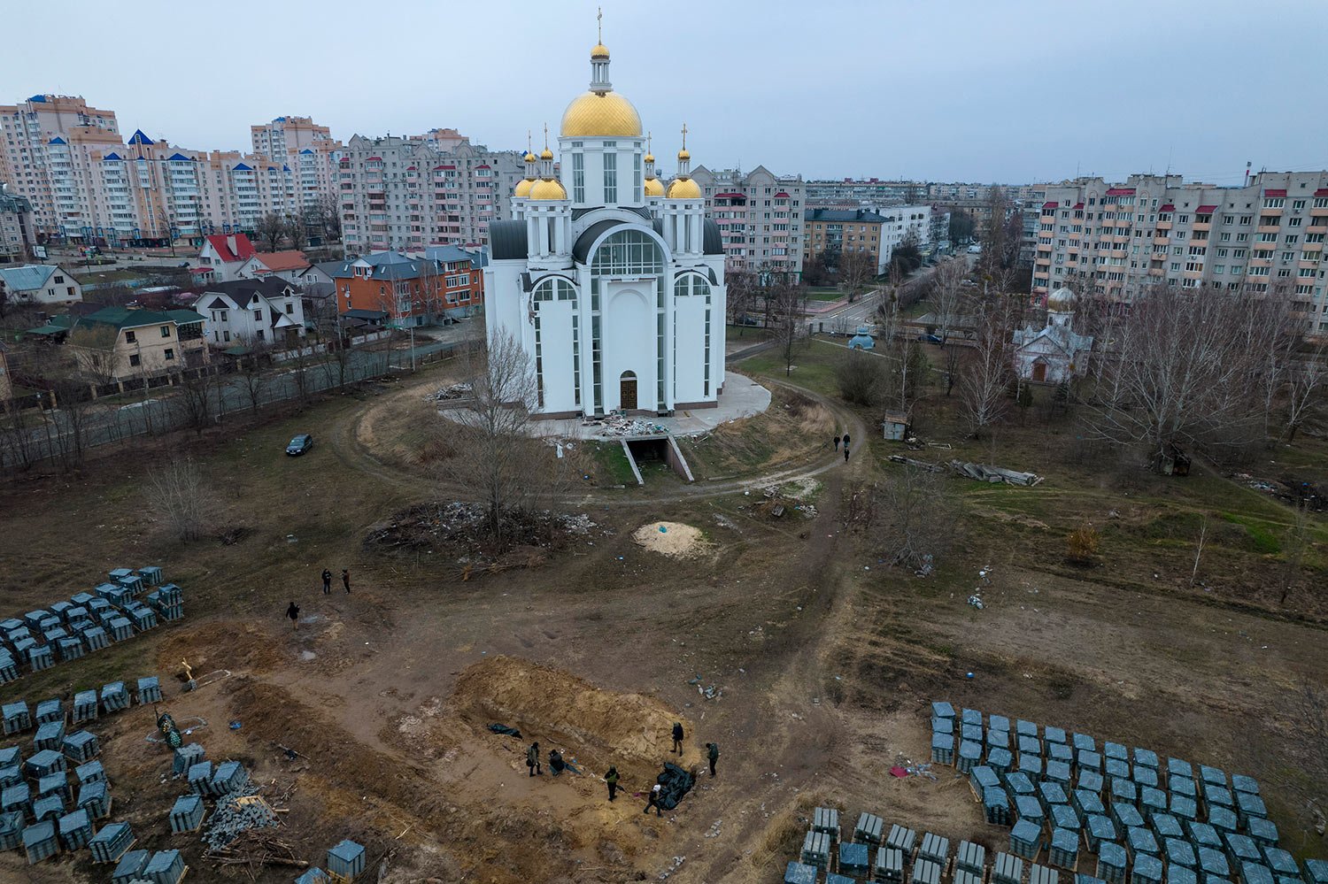  Journalists report next to a mass grave in Bucha, on the outskirts of Kyiv, Ukraine, Tuesday, April 5, 2022. (AP Photo/Rodrigo Abd) 