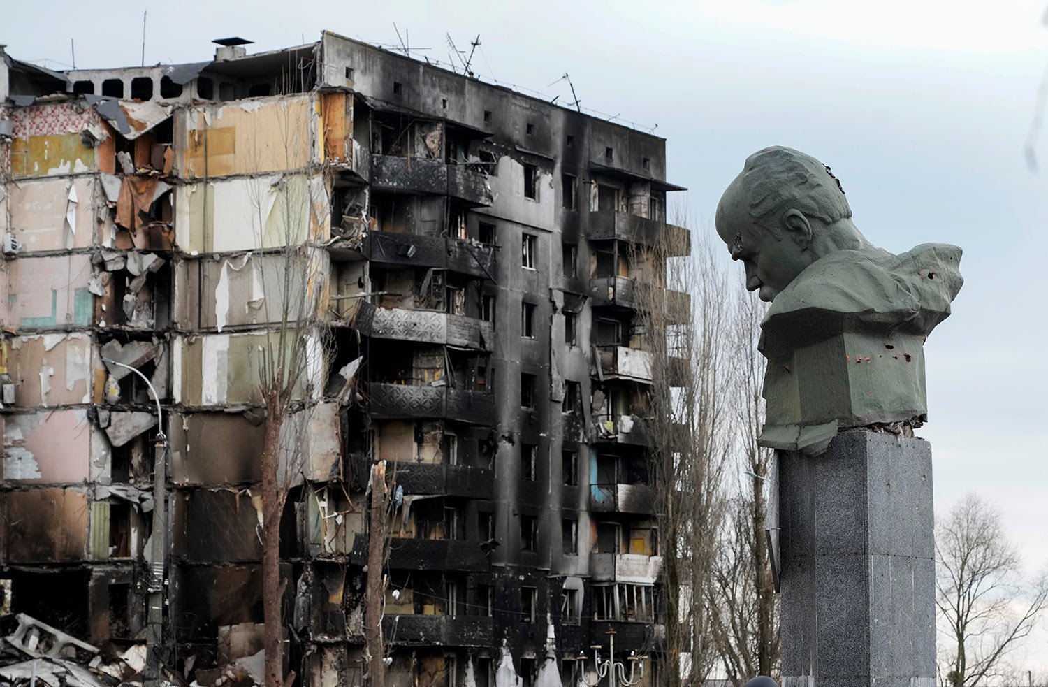  A monument to Taras Shevchenko, a Ukrainian poet and a national symbol, stands near an apartment ruined in the Russian shelling in the central square in Borodyanka, Ukraine, Wednesday, Apr. 6, 2022. (AP Photo/Efrem Lukatsky) 