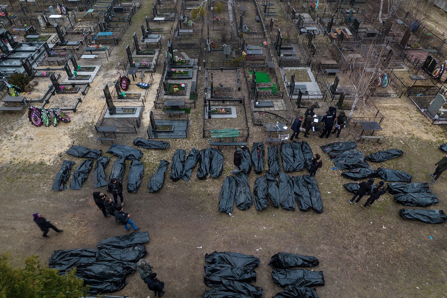  Policemen work on the identification process following the killing of civilians in Bucha, before sending the bodies to the morgue, on the outskirts of Kyiv, Ukraine, Wednesday, April 6, 2022. (AP Photo/Rodrigo Abd) 