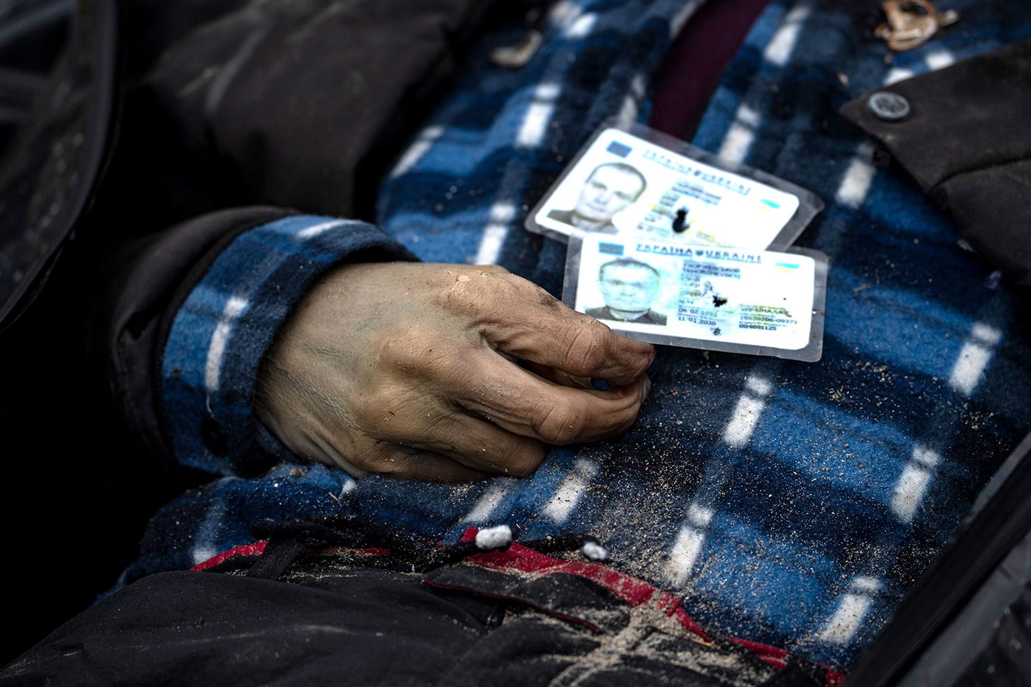 Identification cards rest on a man as policemen work to identify people following the killing of civilians in Bucha, before sending the bodies to the morgue, on the outskirts of Kyiv, Ukraine, Wednesday, April 6, 2022. (AP Photo/Rodrigo Abd) 