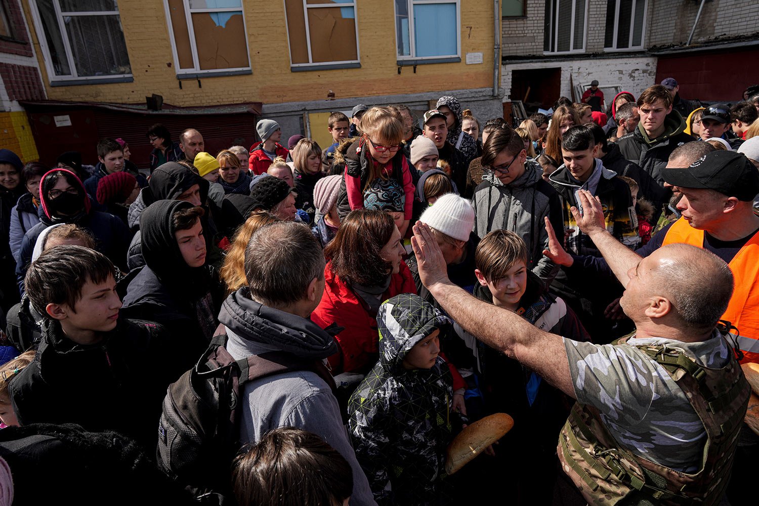  People wait to receive humanitarian aid in a school yard in Chernihiv, Ukraine, Thursday, April 7, 2022. (AP Photo/Evgeniy Maloletka) 