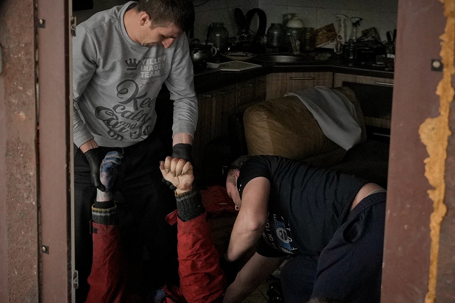  Municipal workers remove the body of a man who died from a house in Bucha, Ukraine, Thursday, April 7, 2022. (AP Photo/Vadim Ghirda) 