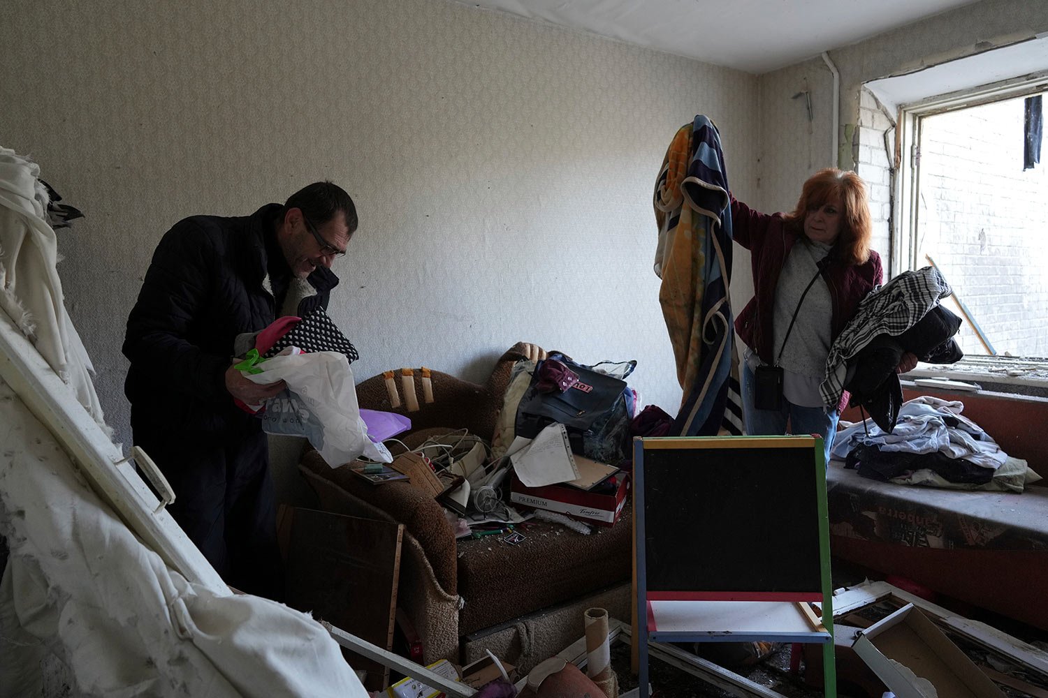  Serhiy, left, and Liumila collect unbroken belongings at their children's apartments damaged by a Russian attack on the outskirts of Chernihiv, Ukraine, Thursday, April 7, 2022. (AP Photo/Evgeniy Maloletka) 