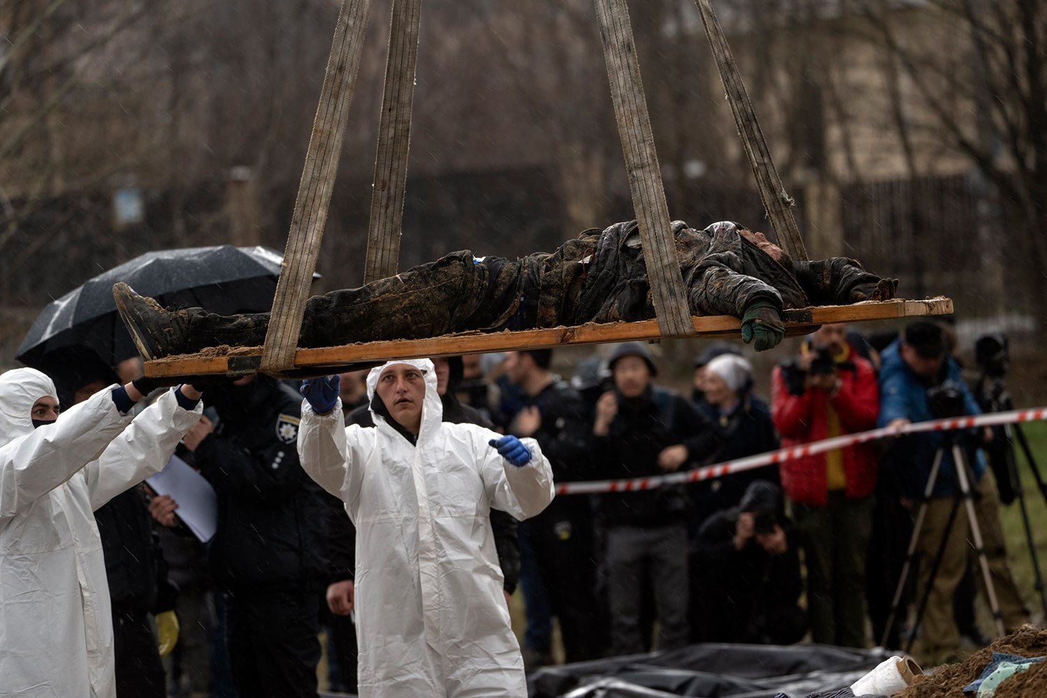  Forensic workers carry the corpse of a civilian killed during the war against Russia after collecting it from a mass grave in Kyiv, Ukraine, Friday, April 8, 2022. (AP Photo/Rodrigo Abd) 