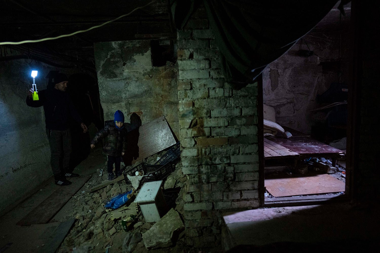  Vlad, 6, walks with his father Ivan, 40, inside the basement where they lived during the war in Bucha, on the outskirts of Kyiv, Ukraine, Friday, April 8, 2022. Vlad's mother died during the confinement in a basement for more than a month during the