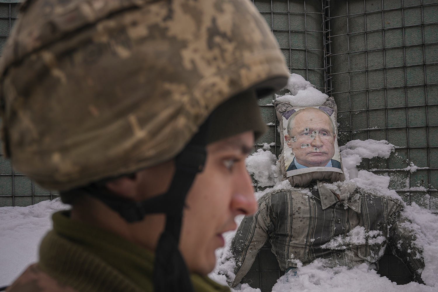  A Ukrainian serviceman speaks, backdropped by a bullet riddled effigy of Russian President Vladimir Putin, during a media interview at a frontline position in the Luhansk region, eastern Ukraine, Tuesday, Feb. 1, 2022. (AP Photo/Vadim Ghirda) 