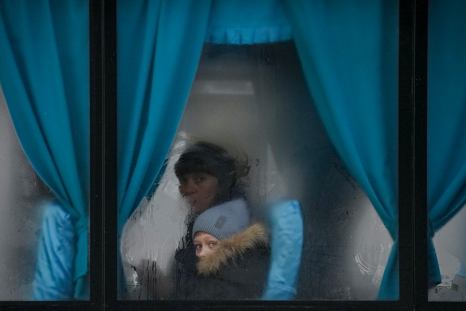  A woman and child peer out of the window of a bus as they leave Sievierodonetsk, the Luhansk region, in eastern Ukraine, Thursday, Feb. 24, 2022. (AP Photo/Vadim Ghirda) 