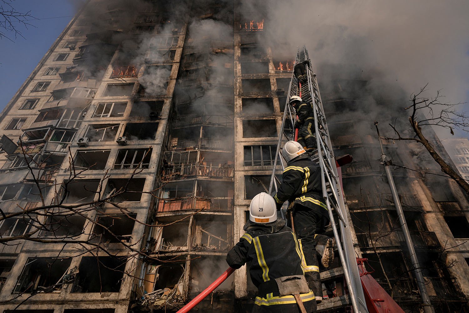  Firefighters climb a ladder while working to extinguish a blaze in a destroyed apartment building after a bombing in a residential area in Kyiv, Ukraine, Tuesday, March 15, 2022. (AP Photo/Vadim Ghirda) 