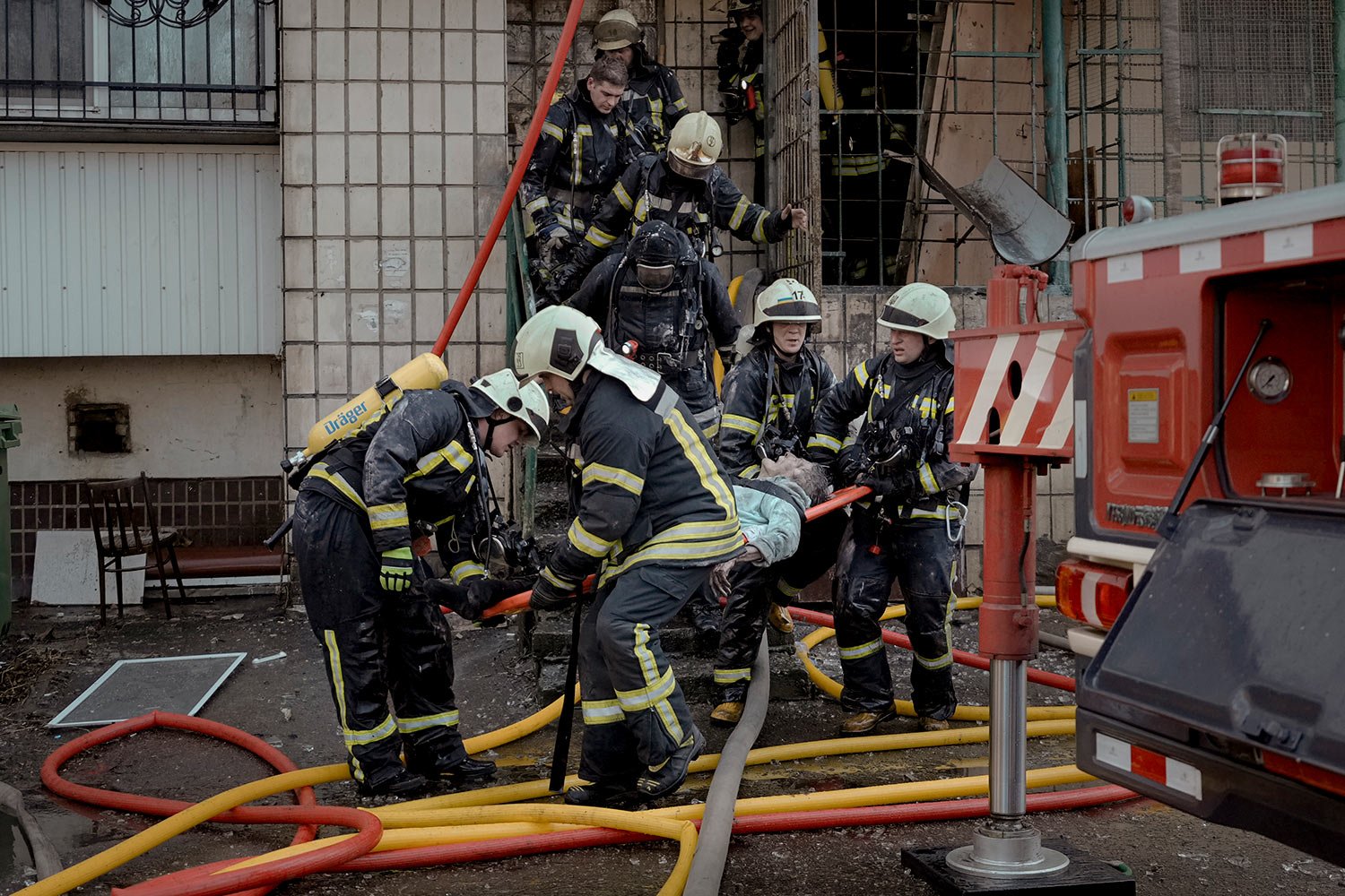  Firefighters carry the dead body of an elderly woman after a bombing in a residential area in Kyiv, Ukraine, Tuesday, March 15, 2022. (AP Photo/Vadim Ghirda) 