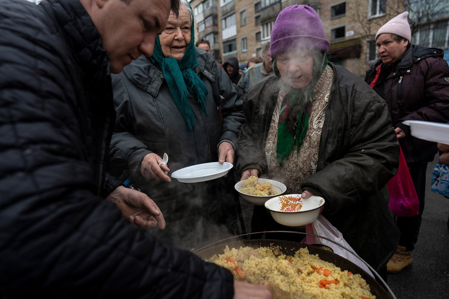  Neighbours receive free food from a soup kitchen in Bucha, in the outskirts of Kyiv, Ukraine, Saturday, April 9, 2022. (AP Photo/Rodrigo Abd) 