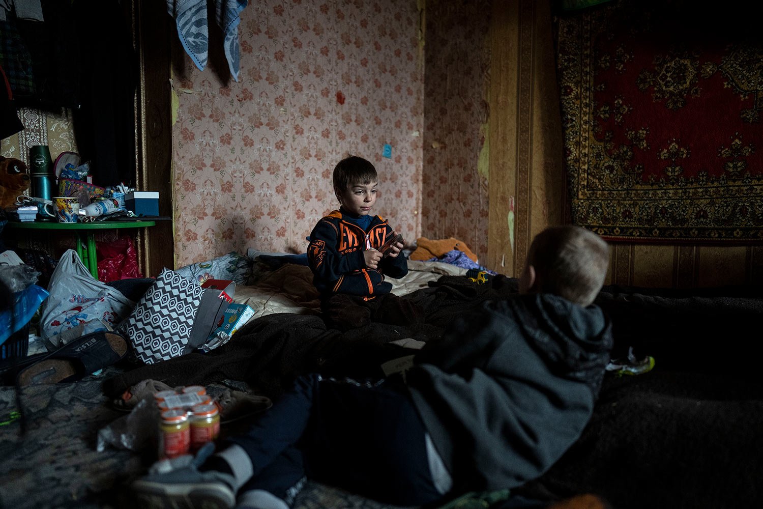  Vlad, 6, plays cards with a friend inside his house in Bucha, in the outskirts of Kyiv, Ukraine, Saturday, April 9, 2022. Vlad's mother died during their confinement in a basement for more than a month during the occupation of the Russian army. (AP 