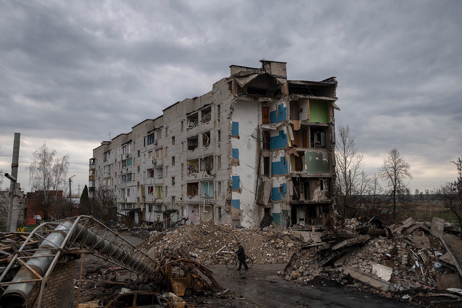  A man with a bicycle walks in front of a destroyed apartment building in the town of Borodyanka, Ukraine, on Saturday, April 9, 2022. (AP Photo/Petros Giannakouris) 