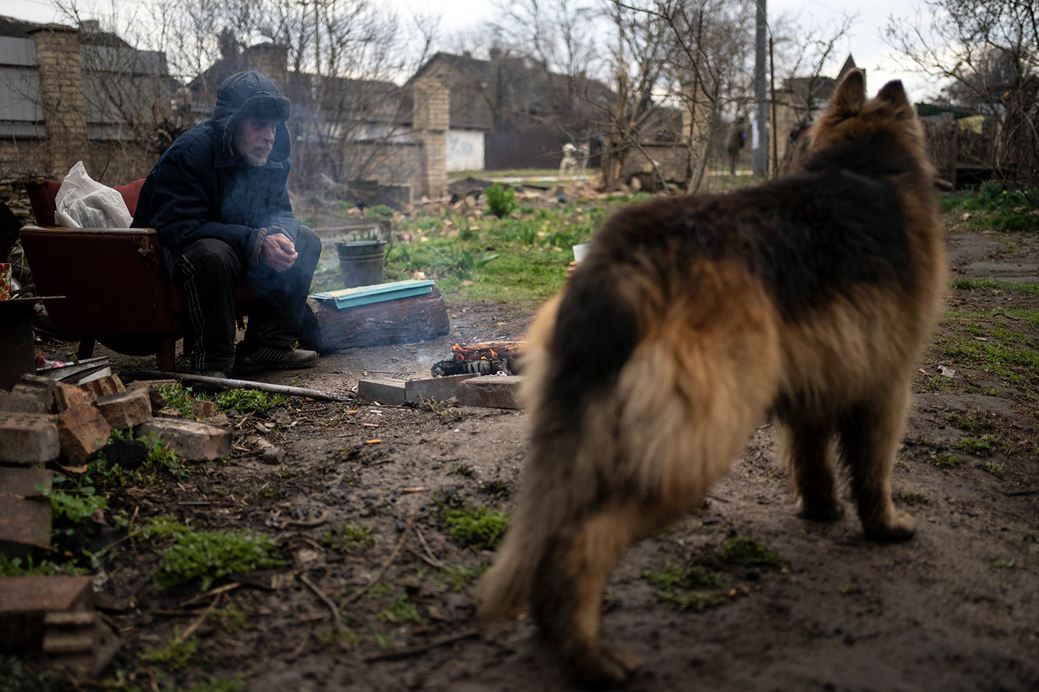  Gregoriev warms himself with a fire in the yard of his house in Bucha, in the outskirts of Kyiv, Ukraine, Saturday, April 9, 2022, which was badly damaged in the war caused by Russia's invasion. (AP Photo/Rodrigo Abd) 