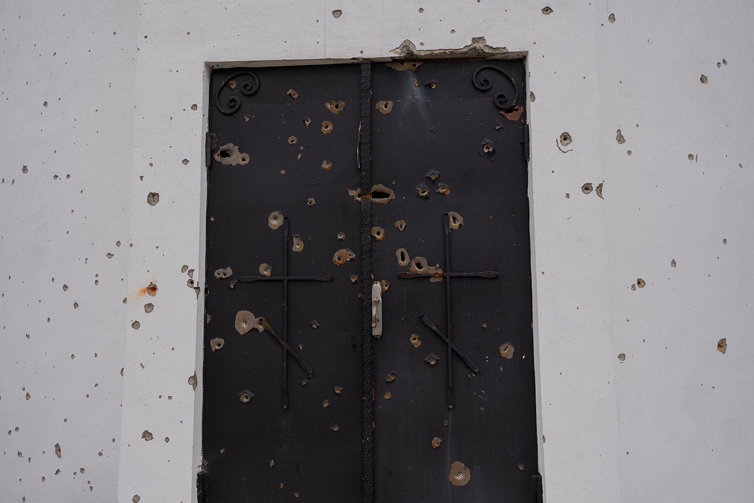  A door of a church is damaged from shrapnel following a Russian attack in the previous weeks, in the town of Makarov, Kyiv region, Ukraine, on Sunday, April 10, 2022. (AP Photo/Petros Giannakouris) 