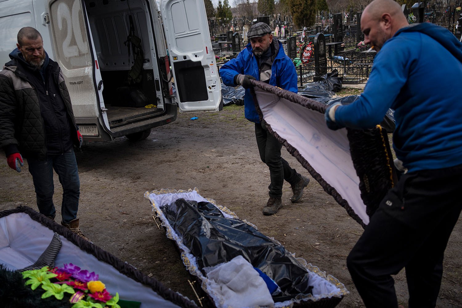  Cemetery workers prepare the coffin for a person killed during the war with Russia, in Bucha, in the outskirts of Kyiv, Ukraine, Monday, April 11, 2022. (AP Photo/Rodrigo Abd) 