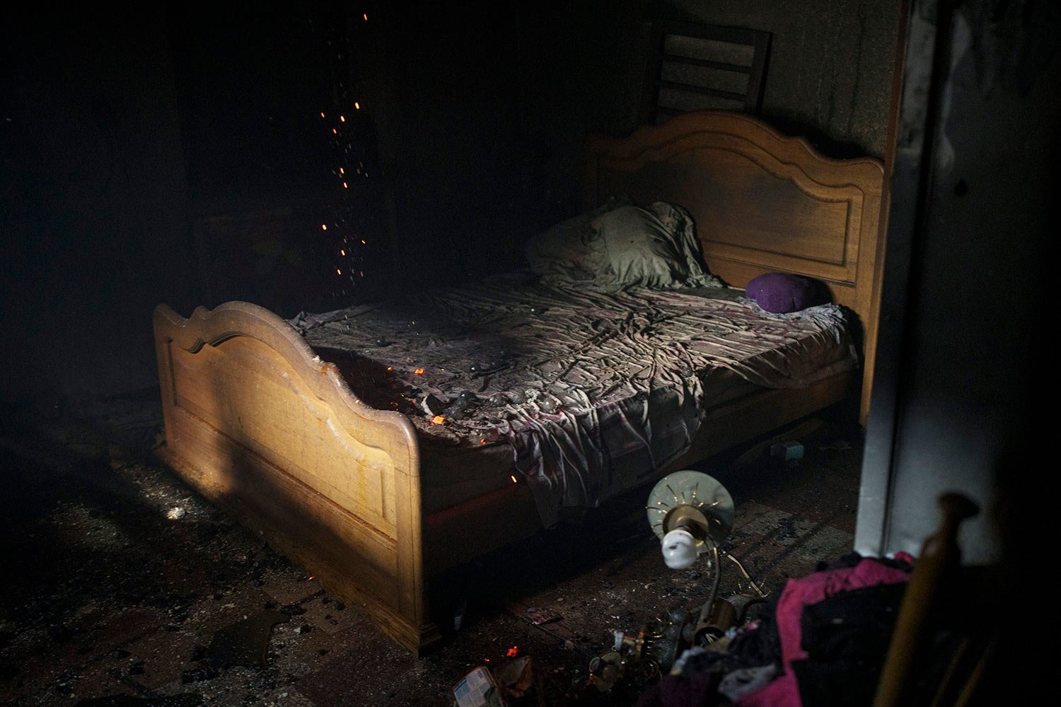  Embers smolder on a bed as firefighters work to extinguish a fire at a house after a Russian attack in Kharkiv, Ukraine, Monday, April 11, 2022. (AP Photo/Felipe Dana) 