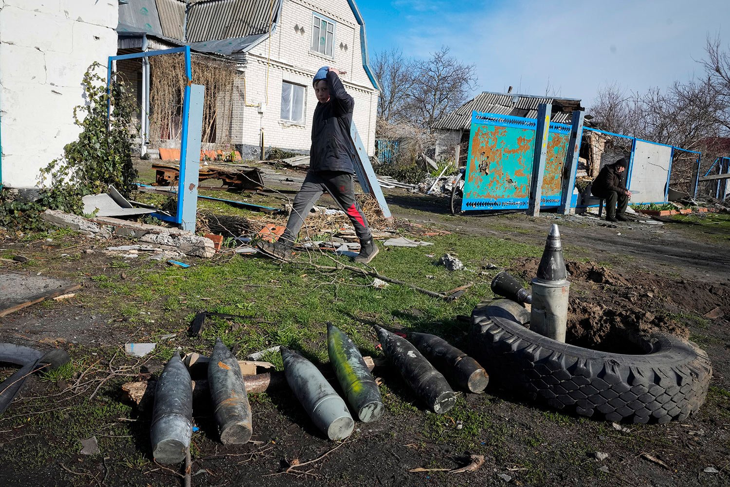  A boy walks by unexploded Russian shells in the village of Andriyivka close to Kyiv, Ukraine, Monday, April 11, 2022. (AP Photo/Efrem Lukatsky) 