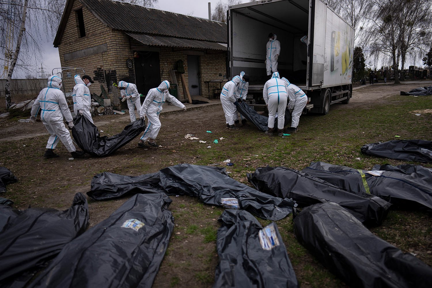  Volunteers load bodies of civilians killed in Bucha onto a truck to be taken to a morgue for investigation, on the outskirts of Kyiv, Ukraine, Tuesday, April 12, 2022. (AP Photo/Rodrigo Abd) 