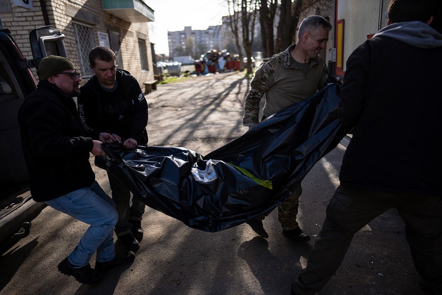  Volunteers carry the body of a man killed during the war to a refrigerated container in Bucha, in the outskirts of Kyiv, Ukraine, Thursday April 14, 2022. (AP Photo/Rodrigo Abd) 