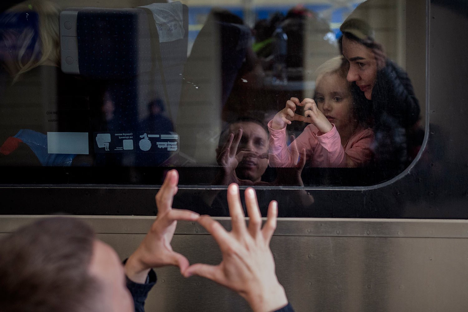  Ukrainian Nicolai, 41, says goodbye to his daughter Elina, 4, and his wife Lolita, on a train bound for Poland fleeing from the war at the train station in Lviv, western Ukraine, Friday, April 15, 2022. (AP Photo/Emilio Morenatti) 