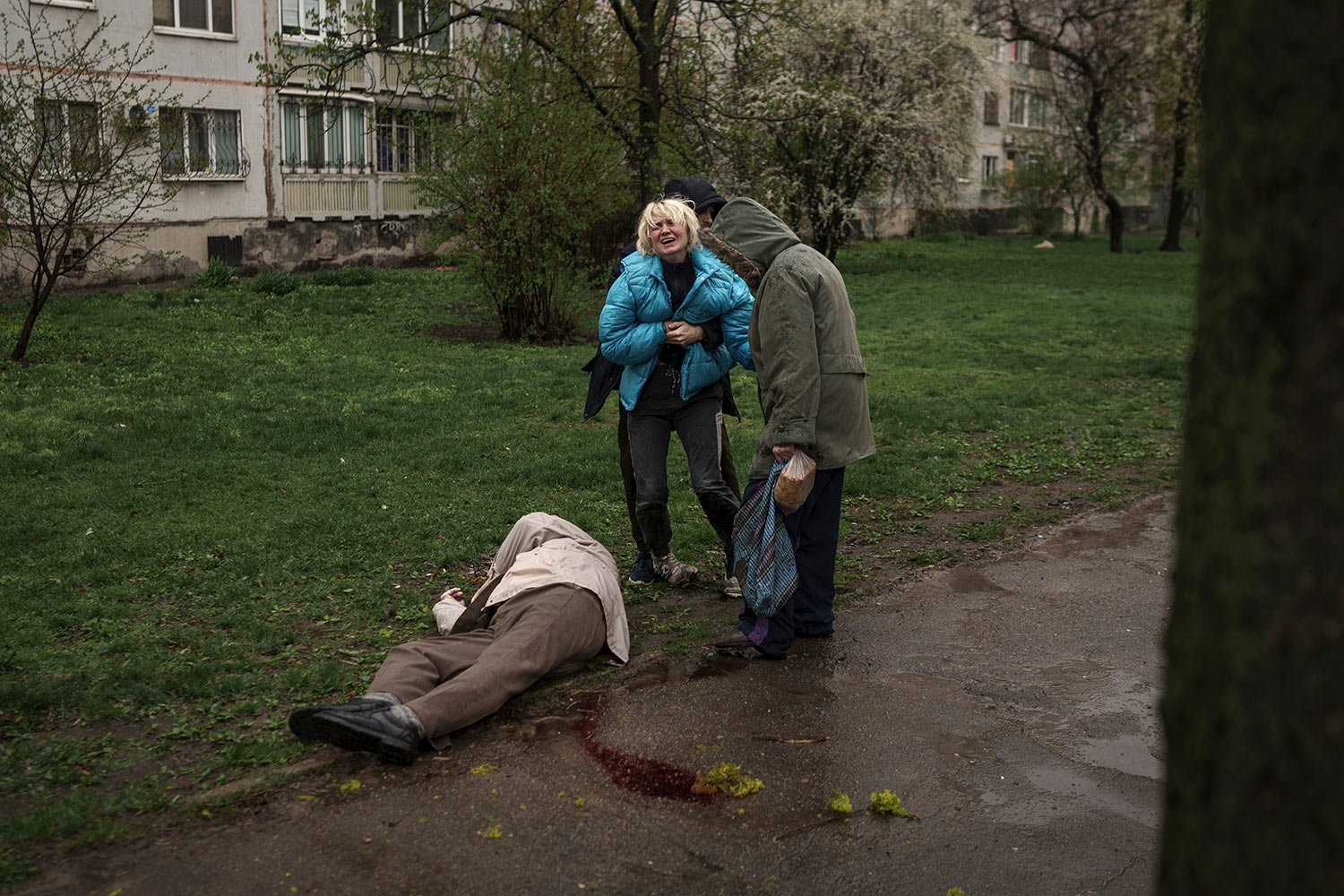  A woman cries next to the body of her father lying on the ground after a Russian attack in Kharkiv, Ukraine, Monday, April 18, 2022. (AP Photo/Felipe Dana) 