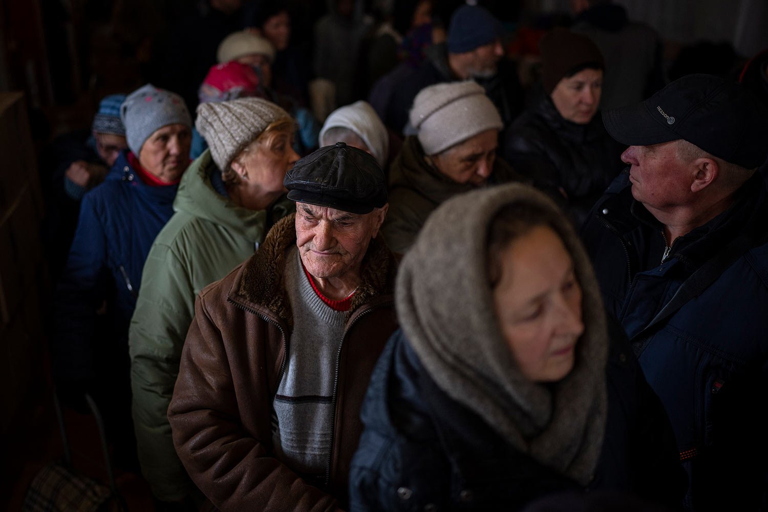  Ukrainian men queue inside a church to receive humanitarian aid donated by European Union in Bucha, on the outskirts of Kyiv, on Tuesday, April 19, 2022. (AP Photo/Emilio Morenatti) 