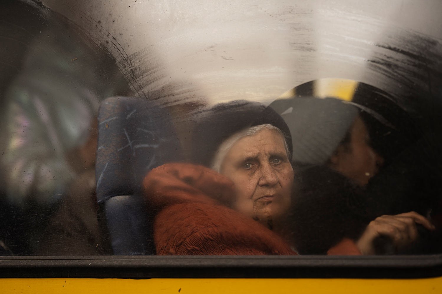  An internally displaced elderly woman from Mariupol looks out of a bus after window arriving at a refugee center fleeing from the Russian attacks, in Zaporizhzhia, Ukraine, Thursday, April 21, 2022. (AP Photo/Leo Correa) 