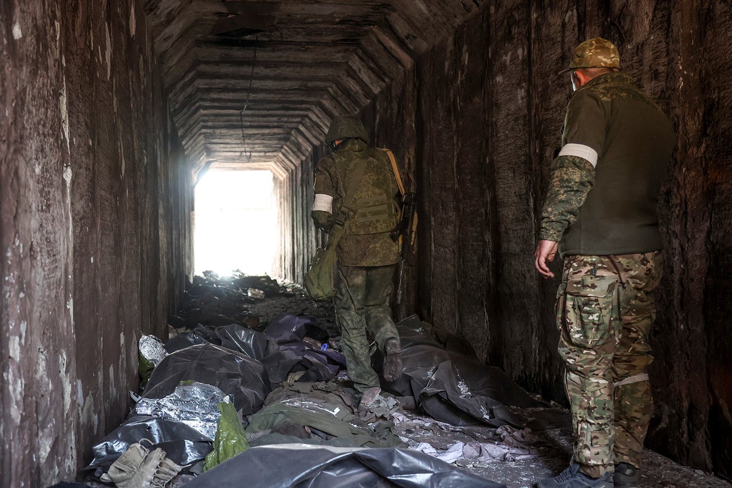  Servicemen of the Donetsk People's Republic militia look at bodies of Ukrainian soldiers placed in plastic bags in a tunnel, part of the Illich Iron & Steel Works Metallurgical Plant, the second largest metallurgical enterprise in Ukraine, in an are