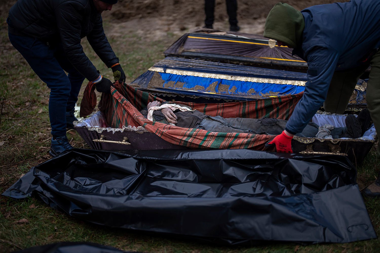  Volunteers put in a bag the body of a civilian killed by Russian army, after been removed from a mass grave, during an exhumation in Mykulychi, Ukraine on Sunday, April 17, 2022. All four bodies in the village grave were killed on the same street, o