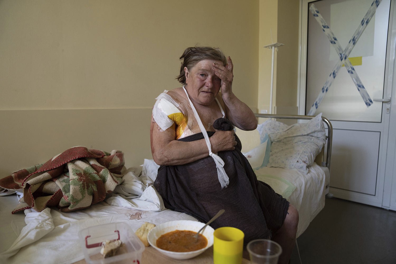  Tamara Oliynyk, 62, sits on a bed after surgery due to injuries form shelling in the village of Shandrigolovo village, as she recuperates at a hospital in Kramatorsk, eastern Ukraine, Tuesday, April 26, 2022. (AP Photo/Evgeniy Maloletka) 