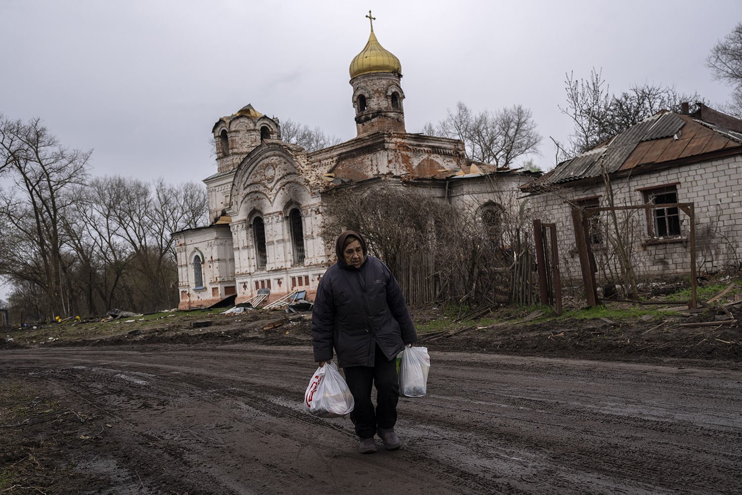  Valentyna Bushtruk, 70, walks in front of a damaged church in Lukashivka in northern Ukraine, Friday, April 22, 2022. Residents said Russian soldiers used the house of worship for storing ammunition and that Ukrainian forces shelled the building to 