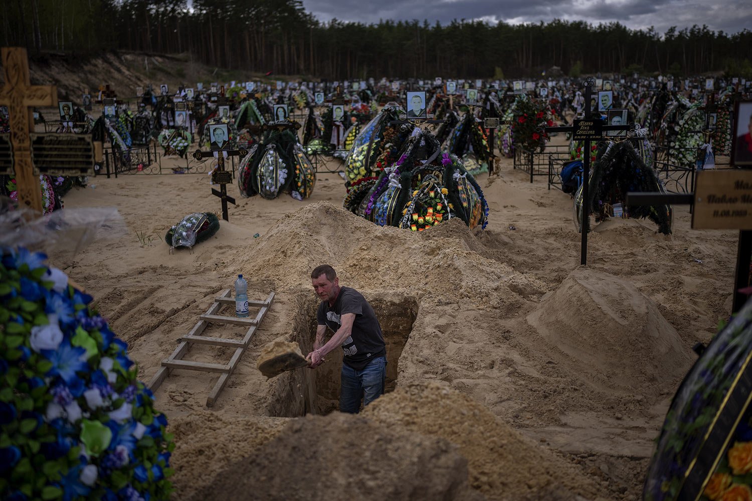  Gravedigger Alexander digs a grave at the cemetery in Irpin on the outskirts of Kyiv, Wednesday, April 27, 2022. (AP Photo/Emilio Morenatti) 