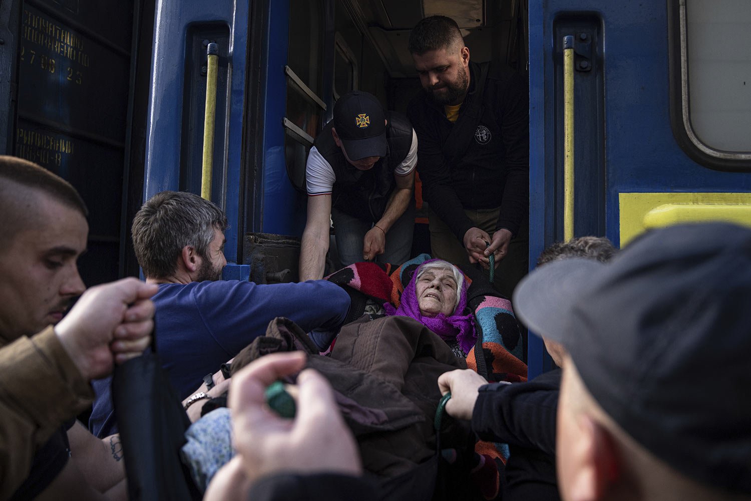  Rescue workers help a disabled, elderly woman enter an evacuation train in Pokrovsk in eastern Ukraine, Tuesday, April 26, 2022. (AP Photo/Evgeniy Maloletka) 