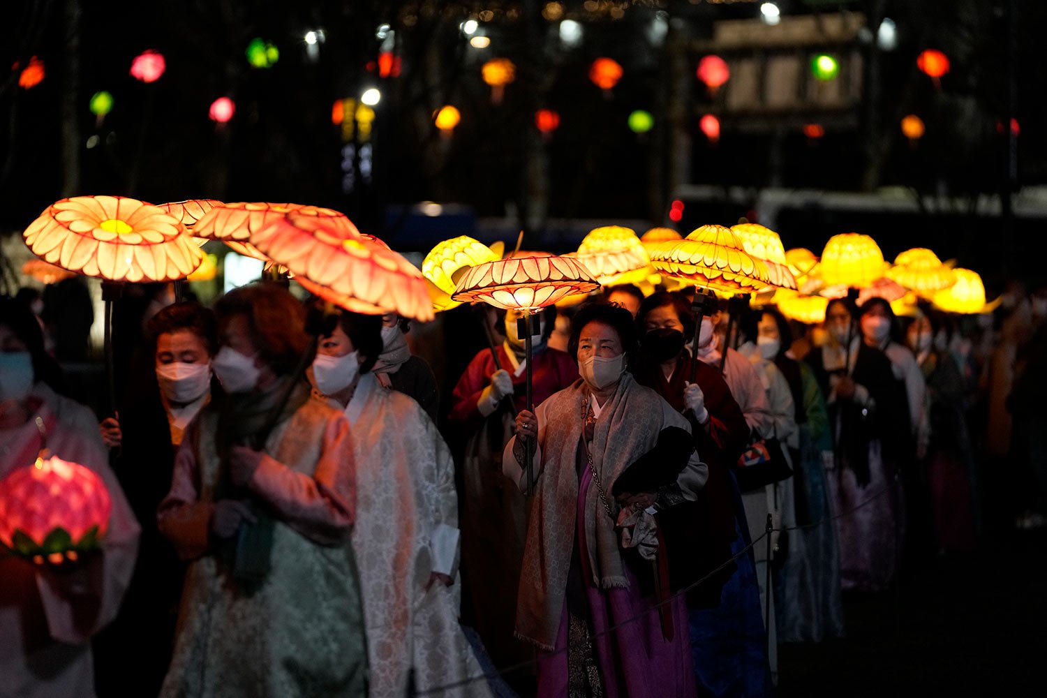  South Korean Buddhists wearing face masks, carry colorful lotus lanterns during the lighting ceremony to celebrate for the upcoming birthday of Buddha on May 8, in Seoul, South Korea, Tuesday, April 5, 2022. (AP Photo/Lee Jin-man) 