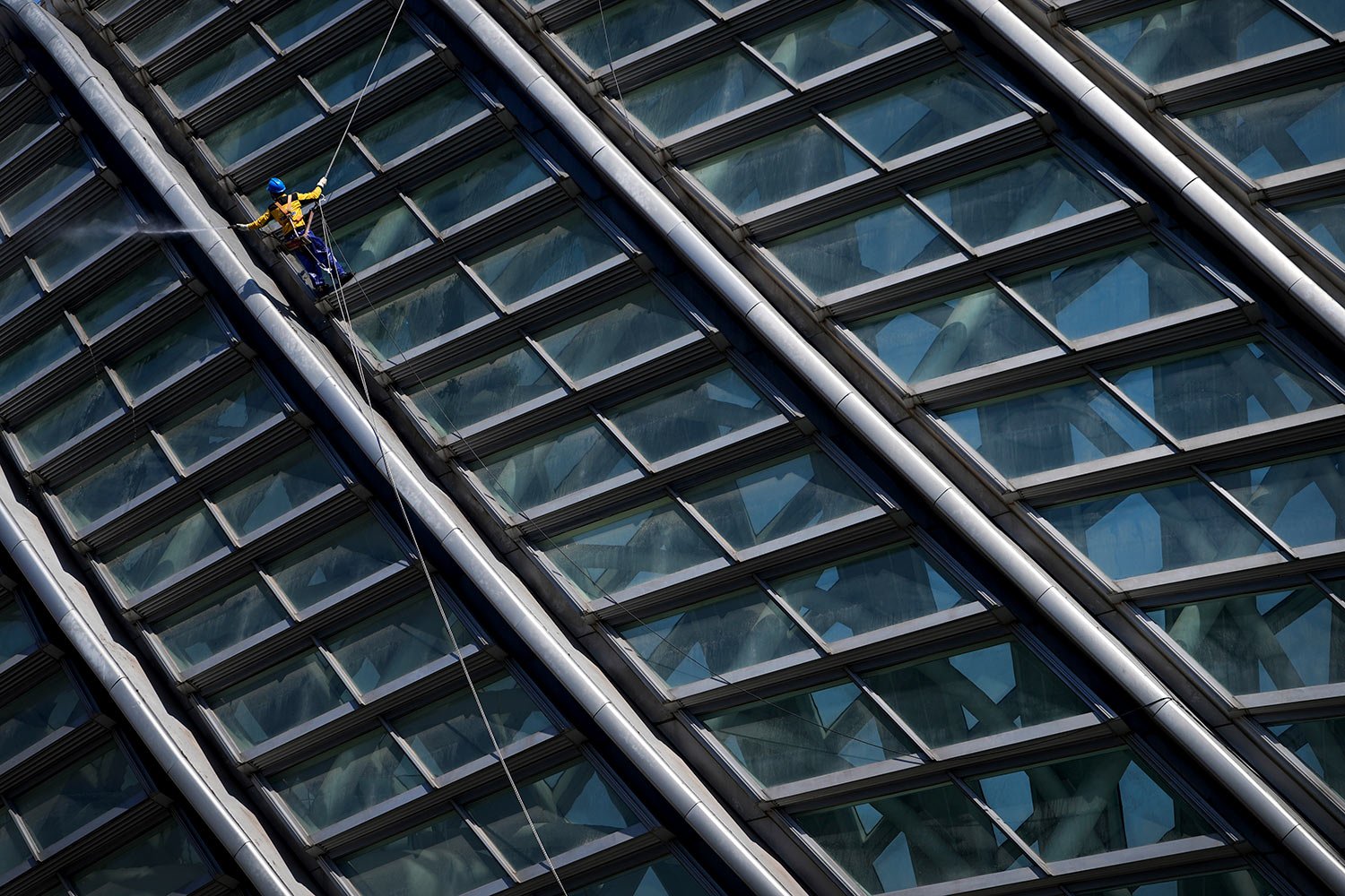  A window washer descends on a rope as he cleans the window panels of the Phoenix Center, Sunday, April 3, 2022, in Beijing. (AP Photo/Andy Wong) 