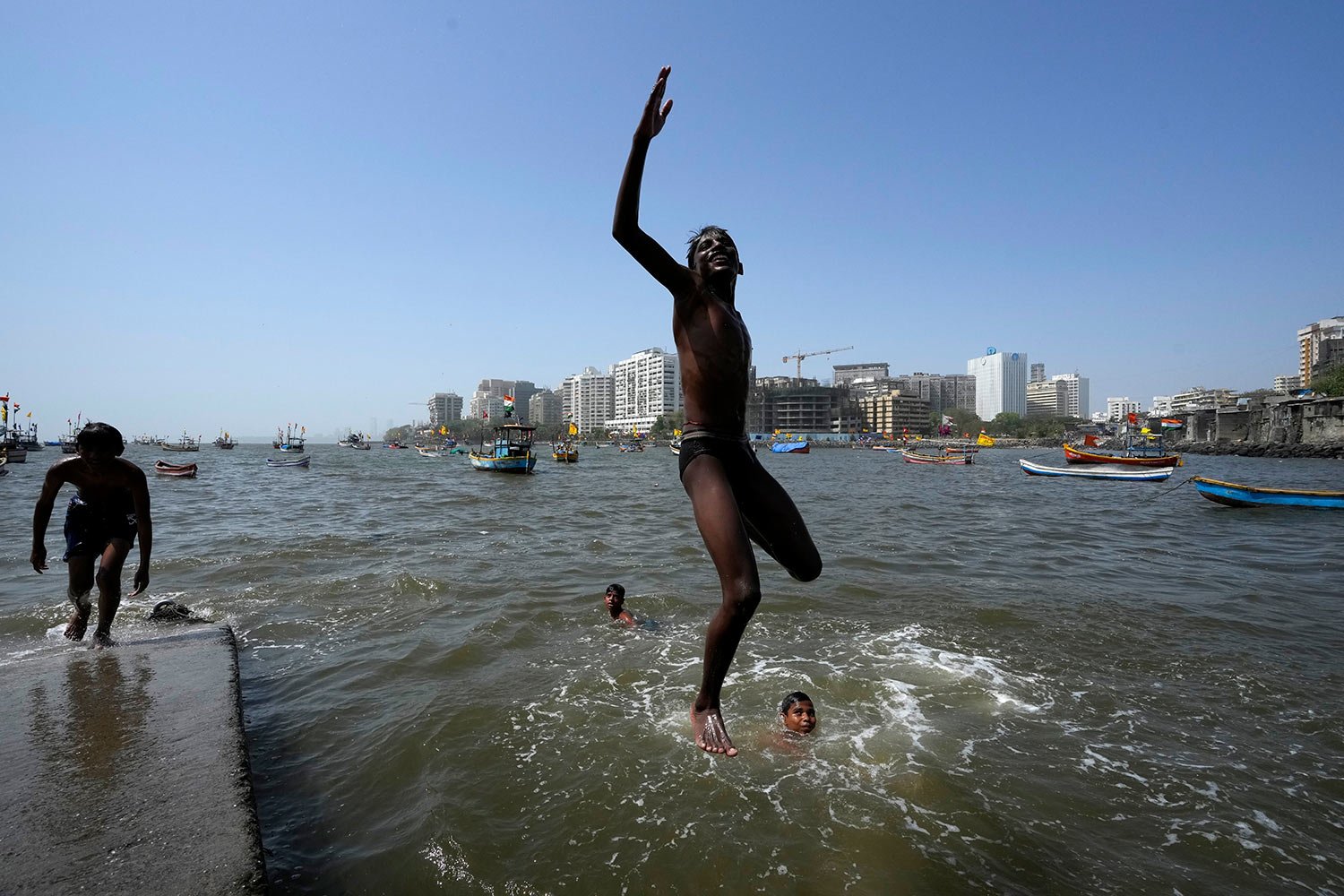  A boy jumps into the waters of the Arabian Sea in Mumbai, India, Friday, April 1, 2022. (AP Photo/ Rajanish Kakade) 