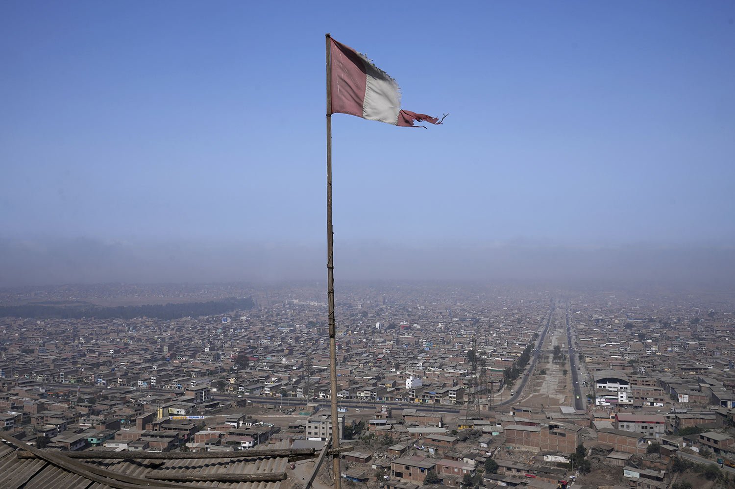  A battered Peruvian flag flies from the roof of a soup kitchen in the Villa Maria neighborhood of Lima, Peru, April 12, 2022. Soup kitchens are on the rise as a lifeline as global spikes in food and fuel prices are proving a double whammy for Peru. 