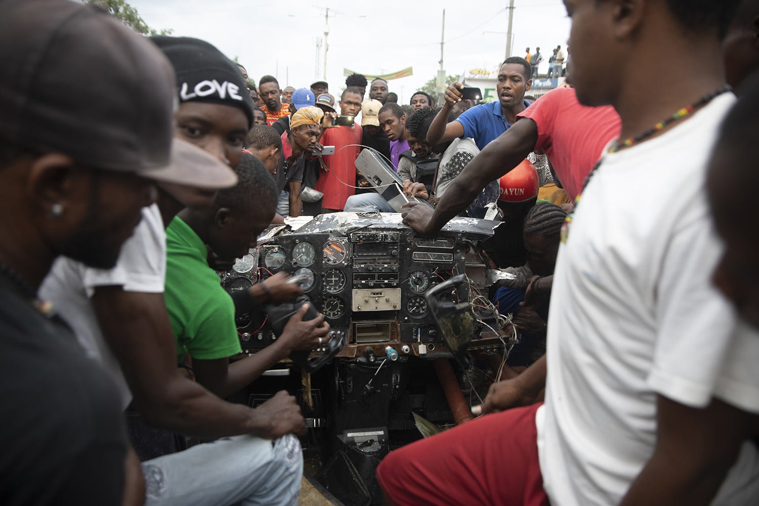  People look at the instrument panel of a small plane that crashed in the community of Carrefour, Port-au-Prince, Haiti, April 20, 2022. Police report that the plane was headed to the southern coastal city of Jacmel when it tried to land in Carrefour