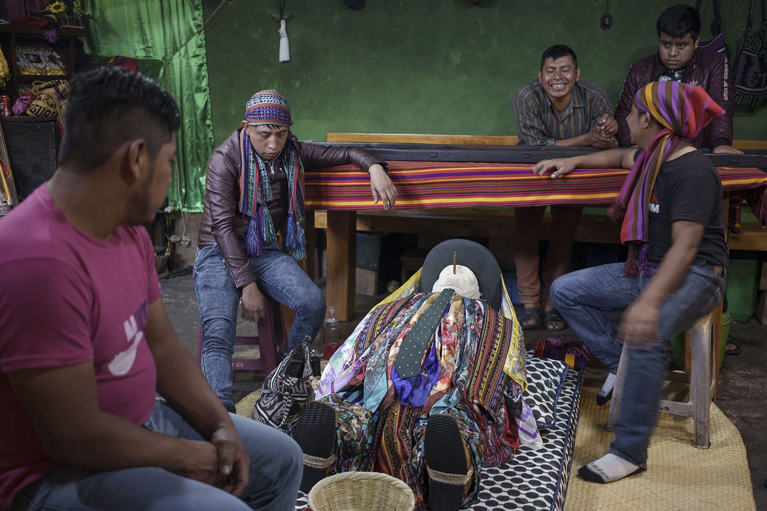  A representation of the folk saint Maximon is surrounded by members of the Santa Cruz brotherhood at their chapel in Santiago Atitlan, Guatemala, April 13, 2022. Maximon followers take part in a procession in his honor, also known as Rilaj Maam, ven