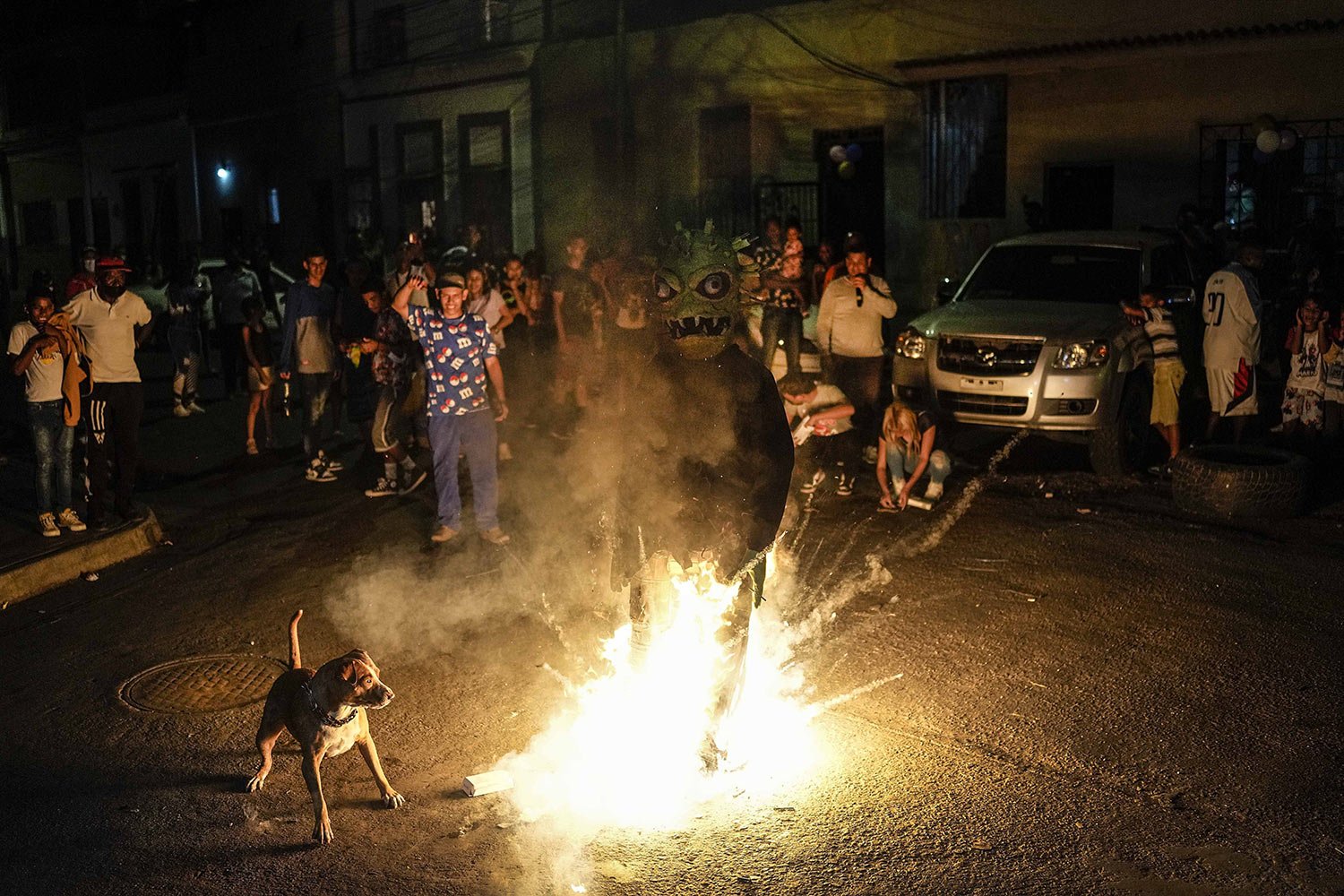  An effigy representing Judas Iscariot and COVID-19 burns as a dog tries to bite it in the San Agustin neighborhood of Caracas, Venezuela, April 17, 2022. The burning of Judas is an Easter-time ritual where an effigy of Judas Iscariot is hanged on Go
