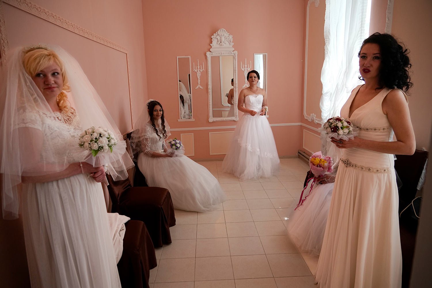  Brides wait to attend a wedding ceremony of several pairs in the center of Berdyansk, in territory under the government of the Donetsk People's Republic, eastern Ukraine, Saturday, April 30, 2022. This photo was taken during a trip organized by the 