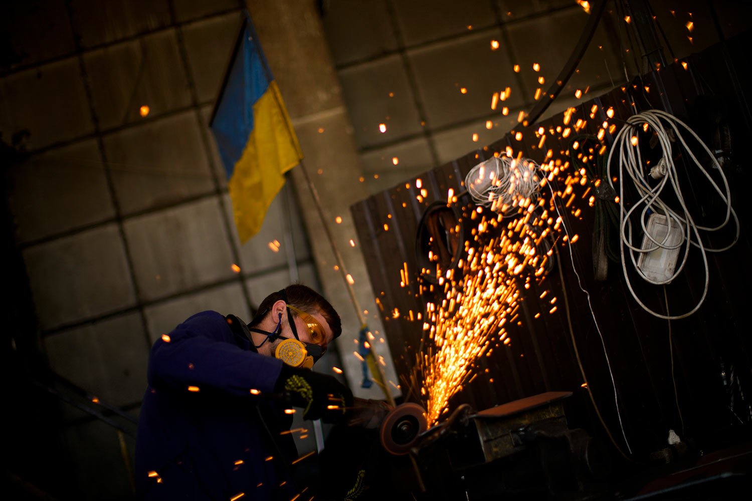  A volunteer shapes metal plates with an angle grinder at a facility producing material for Ukrainian soldiers in Zaporizhzhia, Ukraine, Saturday, May 7, 2022. An old industrial complex in the southeastern Ukrainian riverside city of Zaporizhzhia has