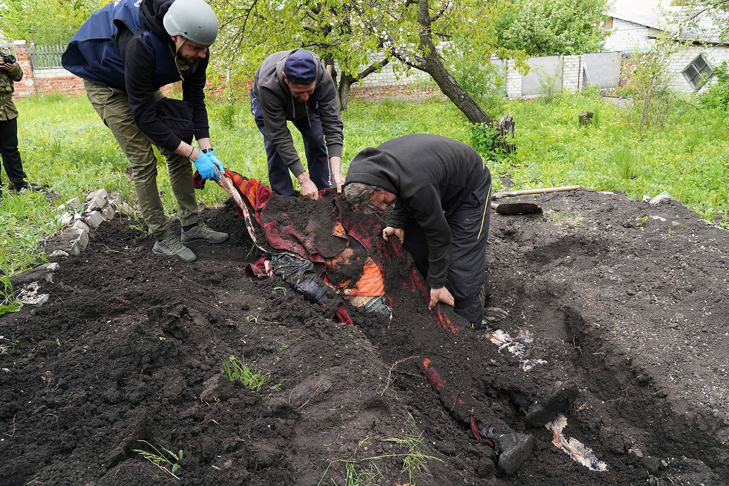  Police and volunteers exhume the bodies of civilians killed by Russian shelling in the village of Stepaky, close to Kharkiv, Ukraine, Wednesday, May 11, 2022. (AP Photo/Andrii Marienko) 