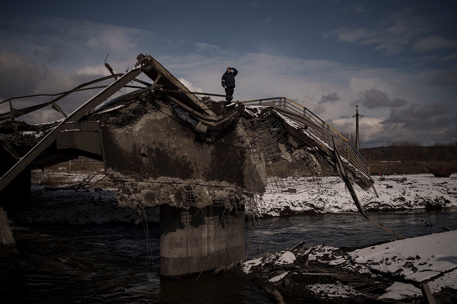  A man stands atop a destroyed bridge in Irpin, on the outskirts of Kyiv, Ukraine, Tuesday, March 8, 2022. (AP Photo/Felipe Dana)  