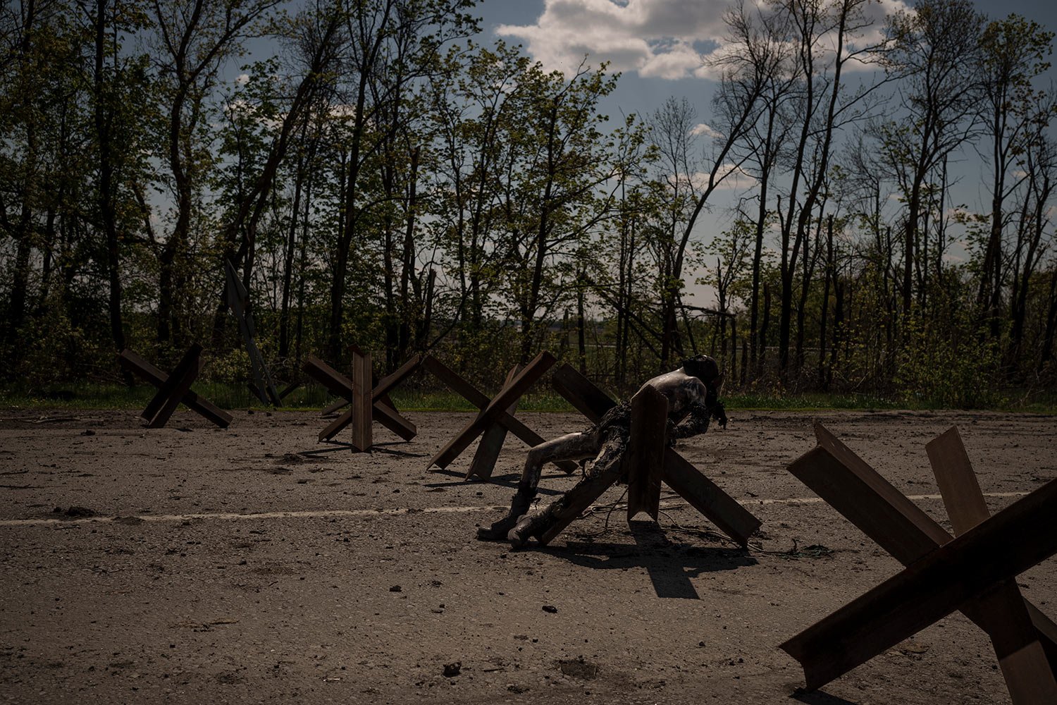  Graphic The body of an unidentified man lies on a road barrier near a village recently retaken by Ukrainian forces on the outskirts of Kharkiv, Ukraine, Saturday, April 30, 2022. (AP Photo/Felipe Dana)  