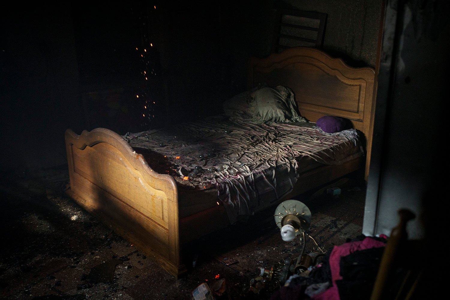  Embers fall on a bed as firefighters work to extinguish a blaze at a house after a Russian attack in Kharkiv, Ukraine, Monday, April 11, 2022. (AP Photo/Felipe Dana)  