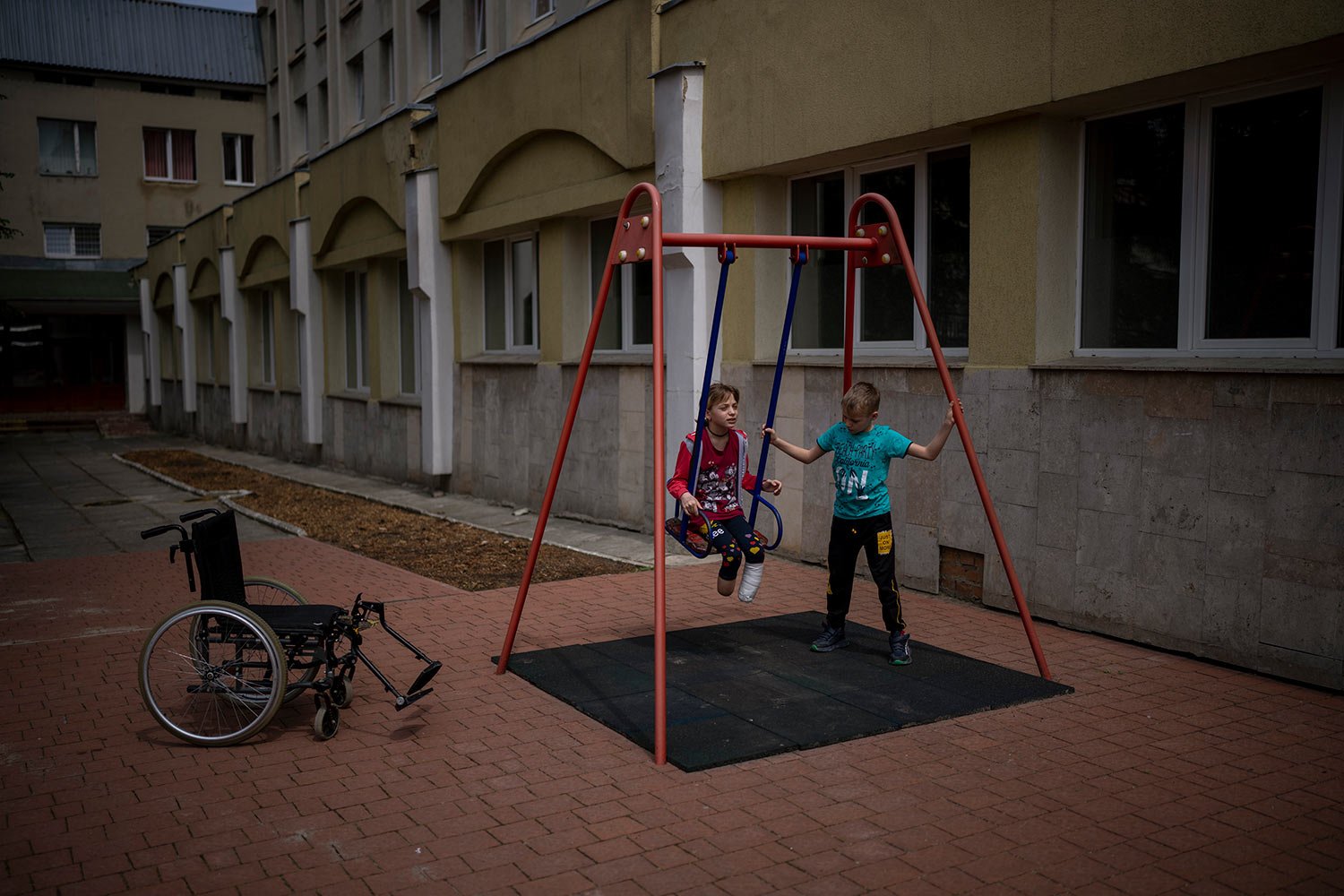  Yarik Stepanenko, 11, pushes his twin-sister Yana on a swing outside a public hospital in Lviv, Ukraine, Thursday, May 12, 2022. On April 8, a missile struck the train station in the eastern city of Kramatorsk where Yana, Yarik and their mother Nata