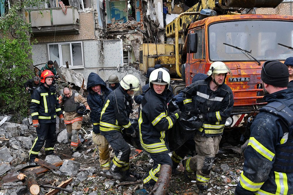  Rescuers carry the body of a civilian at a site of an apartment building destroyed by Russian shelling in Bakhmut, Donetsk region, Ukraine, Wednesday, May 18, 2022. (AP Photo/Andriy Andriyenko) 