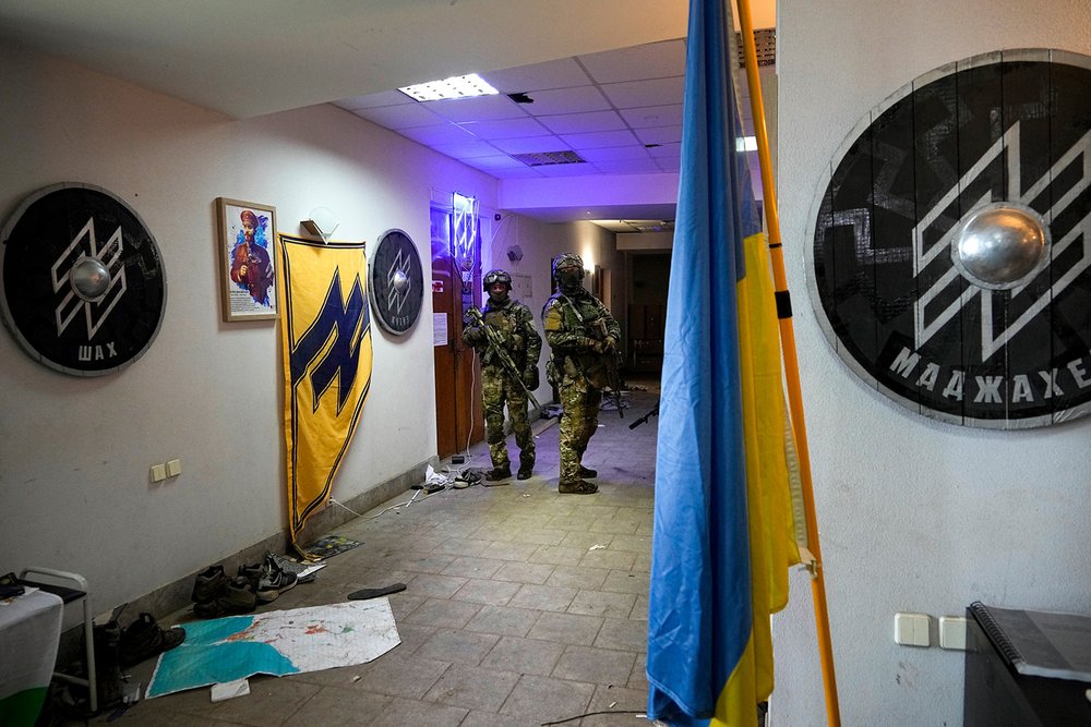  Russian soldiers walk inside Ukraine's Azov Regiment base adorned with the unit's emblems in Yuriivka resort settlement on the coast of Azov Sea not far from Mariupol, in territory under the government of the Donetsk People's Republic, eastern Ukrai
