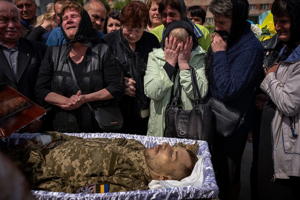  Relatives react next to the body of Pankratov Oleksandr, 49, a Ukrainian military servicemen who was killed in Donetsk province, during his funeral in Lviv, Ukraine, Saturday, May 14, 2022. (AP Photo/Emilio Morenatti) 